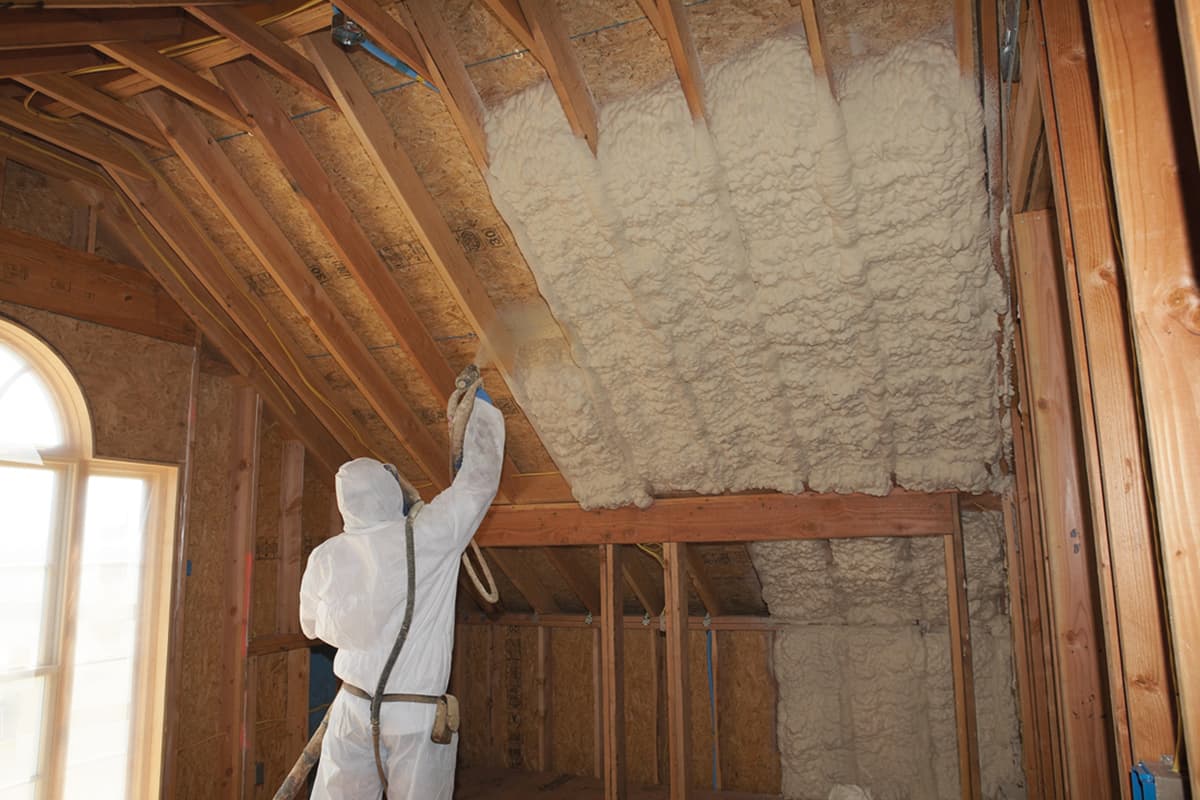Insulation being installed along an attic roofline